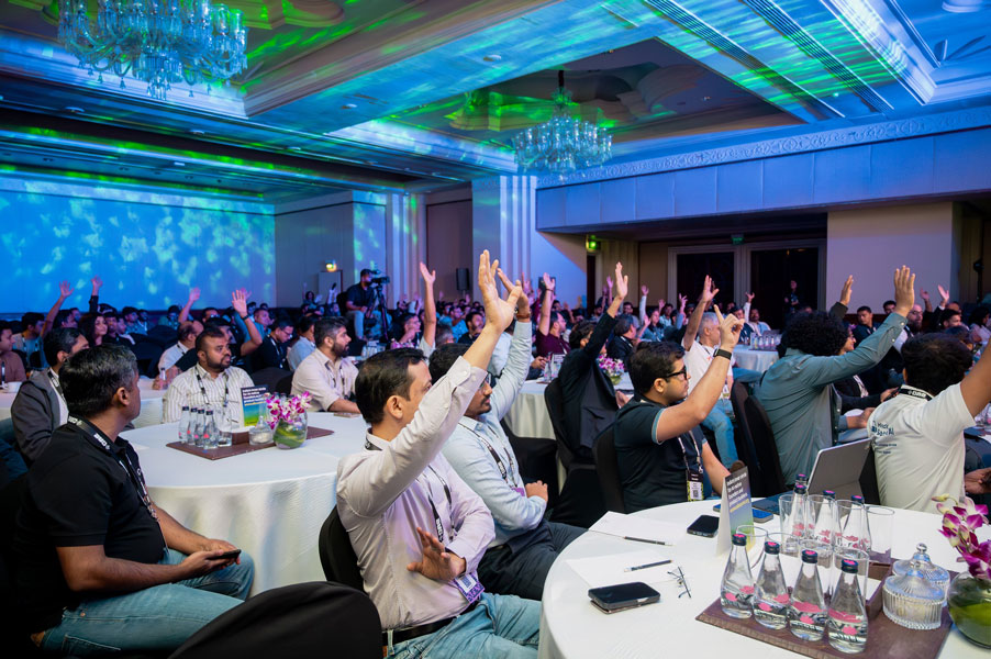 Audience raising their hands during an interactive session